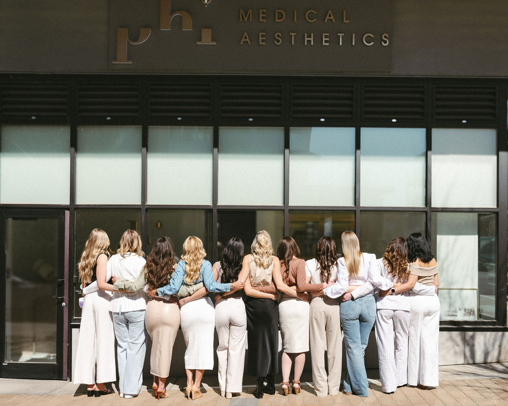 A Calgary branding session with a group of woman hugging each other outside a salon. 