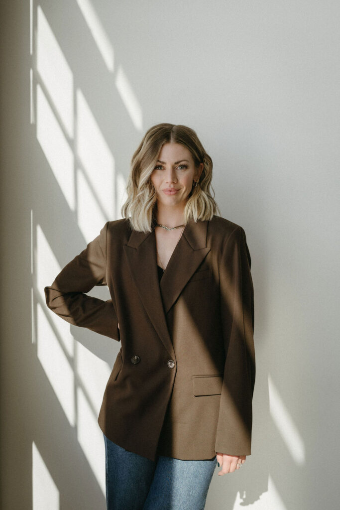 A woman standing in a studio getting her portrait taken. 