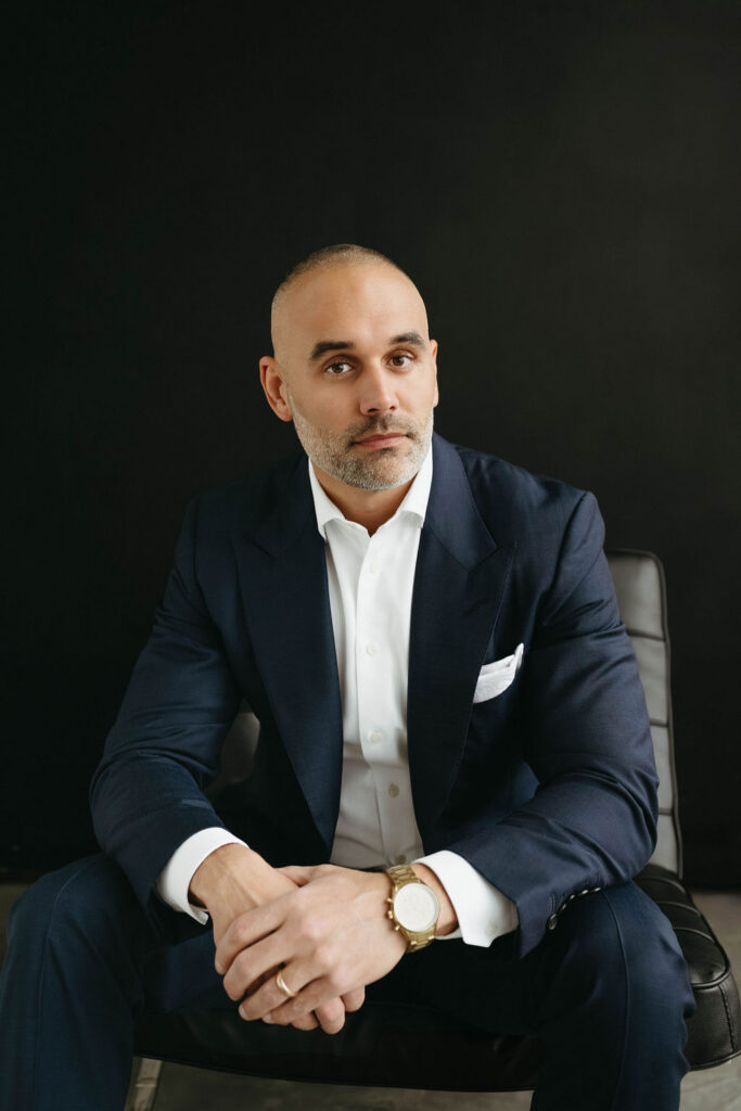 A man sitting on a chair getting his Calgary headshot done in studio.