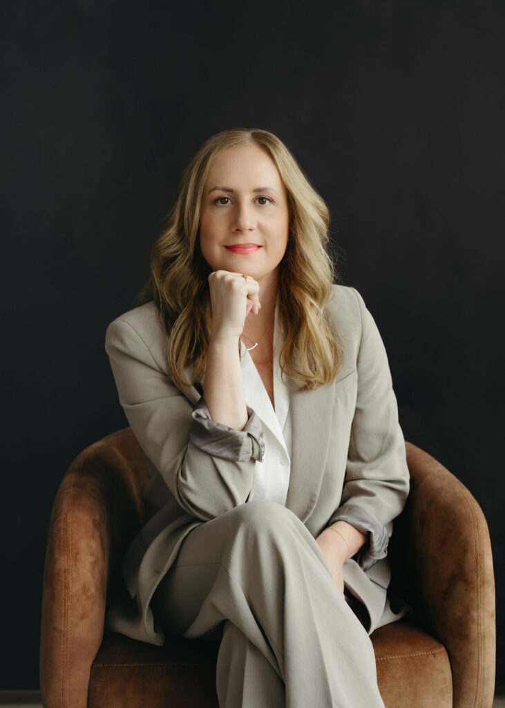 A woman sitting in a chair in a studio in Calgary having her portrait taken.