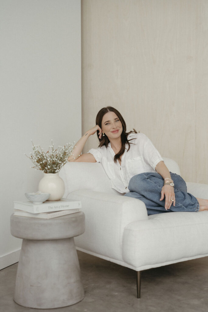 A woman sitting on a chair in a studio having her portrait taken.