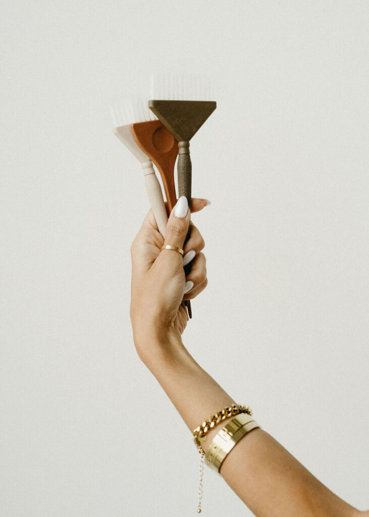A Calgary photographer taking a photo of brushes being held in a woman's hand.